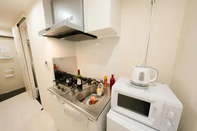 a small kitchen with a sink and a microwave at FL Residence Shinjuku II in Tokyo