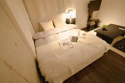 a hotel room with a bed with two books on it at FL Residence Seeikokan III in Tokyo