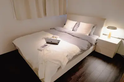 a bedroom with a bed with a laptop on it at FL Residence Seeikokan III in Tokyo
