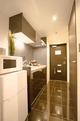a kitchen with a white microwave and a black door at FL Residence Seeikokan III in Tokyo