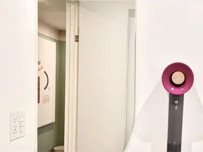 a bathroom with a pink mirror next to a door at \u4e1c\u4eac\u4e0a\u91ce\u8d85\u7ea7\u4e2d\u5fc3 \u8bbe\u8ba1\u5e08\u623f\u95f4Ybob \u4e0a\u91ce\u516c\u56ed3\u5206\u949f \u8f66\u7ad91\u5206\u949f \u8d85\u7ea7\u7e41\u534e \u514d\u8d39wifi \u6234\u68ee\u5439\u98ce in Tokyo