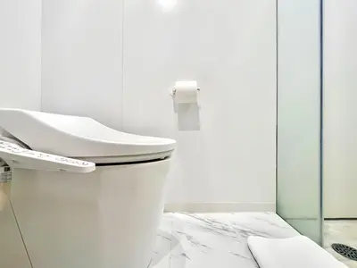 a white bathroom with a toilet and a sink at \u4e1c\u4eac\u4e0a\u91ce\u8d85\u7ea7\u4e2d\u5fc3 \u8bbe\u8ba1\u5e08\u623f\u95f4Ybob \u4e0a\u91ce\u516c\u56ed3\u5206\u949f \u8f66\u7ad91\u5206\u949f \u8d85\u7ea7\u7e41\u534e \u514d\u8d39wifi \u6234\u68ee\u5439\u98ce in Tokyo