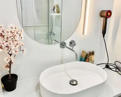 a bathroom with a white sink and a mirror at \u4e1c\u4eac\u4e0a\u91ce\u8d85\u7ea7\u4e2d\u5fc3 \u8bbe\u8ba1\u5e08\u623f\u95f4Ycoe \u4e0a\u91ce\u516c\u56ed3\u5206\u949f \u8f66\u7ad91\u5206\u949f \u8d85\u7ea7\u7e41\u534e \u514d\u8d39wifi \u6234\u68ee\u5439\u98ce in Tokyo