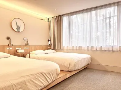 a hotel room with two beds and a window at \u4e1c\u4eac\u4e0a\u91ce\u8d85\u8c6a\u534e4\u4eba\u95f4 \u4e1c\u4eac\u8d85\u7ea7\u4e2d\u5fc3\u8bbe\u8ba1\u5e08\u623f\u95f4Ybod \u4e0a\u91ce\u516c\u56ed3\u5206\u949f \u8f66\u7ad91\u5206\u949f \u8d85\u7ea7\u7e41\u534e \u514d\u8d39wifi \u6234\u68ee\u5439\u98ce in Tokyo