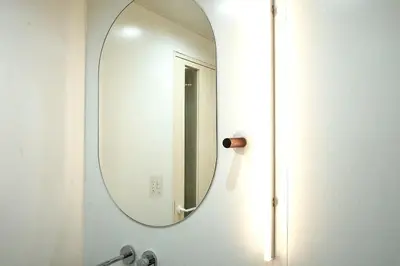 a bathroom with a mirror on a wall at \u4e1c\u4eac\u4e0a\u91ce\u8d85\u8c6a\u534e4\u4eba\u95f4 \u4e1c\u4eac\u8d85\u7ea7\u4e2d\u5fc3\u8bbe\u8ba1\u5e08\u623f\u95f4Ybod \u4e0a\u91ce\u516c\u56ed3\u5206\u949f \u8f66\u7ad91\u5206\u949f \u8d85\u7ea7\u7e41\u534e \u514d\u8d39wifi \u6234\u68ee\u5439\u98ce in Tokyo
