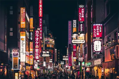 a busy city street at night with neon signs at \u4e0a\u91ce\u8d85\u8c6a\u534e4\u4eba\u95f4 \u4e1c\u4eac\u8d85\u7ea7\u4e2d\u5fc3Ydoa \u8bbe\u8ba1\u5e08\u623f\u95f4 \u4e0a\u91ce\u516c\u56ed3\u5206\u949f \u8f66\u7ad91\u5206\u949f \u8d85\u7ea7\u7e41\u534e \u514d\u8d39wifi \u6234\u68ee\u5439\u98ce in Tokyo