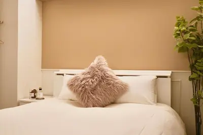 a white bed with a furry pillow on it at 超级奢华 近秋叶原东京站Kaoa奢华套房带厨房 超豪华戴森&POLA顶级配置 4分钟到东京站 3分钟到地铁 in Tokyo