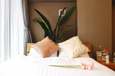 a bed with white sheets and pillows with flowers on it at 都心罕见东京奢华设计师Kcob带榻榻米 戴森&POLA顶级配置4分钟到东京站 20分钟到迪士尼 最大3人 in Tokyo