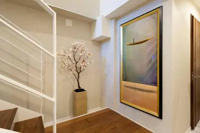 a hallway with a painting and a vase with a tree at 都心罕见东京奢华设计师Keob带榻榻米 戴森&POLA顶级配置4分钟到东京站 20分钟到迪士尼 最大3人 in Tokyo