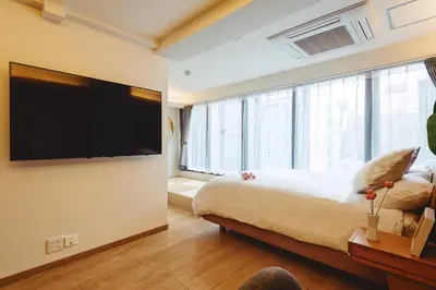 a bedroom with a large bed and a flat screen tv at 都心罕见东京奢华设计师Keob带榻榻米 戴森&POLA顶级配置4分钟到东京站 20分钟到迪士尼 最大3人 in Tokyo