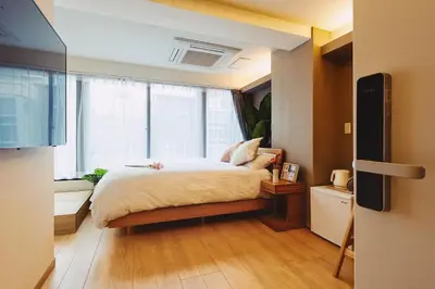 a bedroom with a bed and a large window at 都心罕见东京奢华设计师Kdob带榻榻米 戴森&POLA顶级配置4分钟到东京站 20分钟到迪士尼 最大3人 in Tokyo