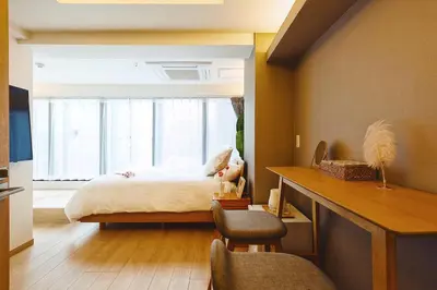 a bedroom with a bed with a window and a desk at 都心罕见东京奢华设计师Kdob带榻榻米 戴森&POLA顶级配置4分钟到东京站 20分钟到迪士尼 最大3人 in Tokyo