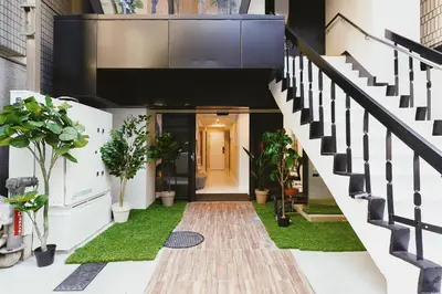 a hallway of a house with plants and stairs at 都心罕见东京奢华设计师Kdob带榻榻米 戴森&POLA顶级配置4分钟到东京站 20分钟到迪士尼 最大3人 in Tokyo