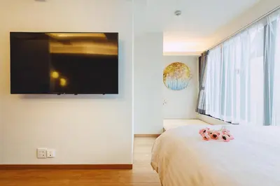 a bedroom with a bed with a flat screen tv on the wall at 都心罕见东京奢华设计师Kdob带榻榻米 戴森&POLA顶级配置4分钟到东京站 20分钟到迪士尼 最大3人 in Tokyo
