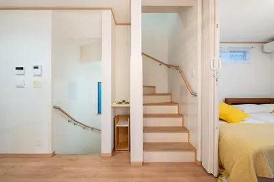 a staircase in a bedroom next to a bed at THE VILLA TAKADANOBABA in Tokyo