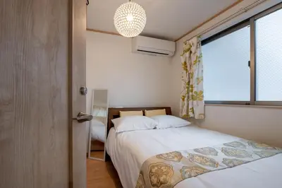a bedroom with two beds and a window at THE VILLA TAKADANOBABA in Tokyo