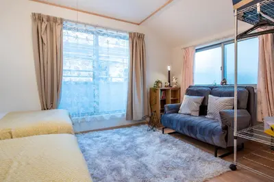 a living room with a couch and a large window at THE VILLA TAKADANOBABA in Tokyo