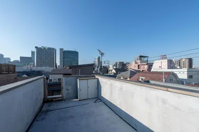 a balcony with a view of a city skyline at \u65b0\u5bbf6\u4e01\u76ee\u6238\u5efa in Tokyo