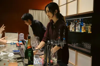 a woman standing at a bar with a bottle of wine at \u4e07\u96f7\u30db\u30c6\u30eb in Tokyo