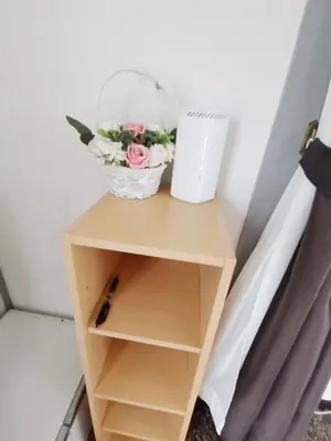 a small wooden shelf with a flower bouquet on it at White house in Tokyo