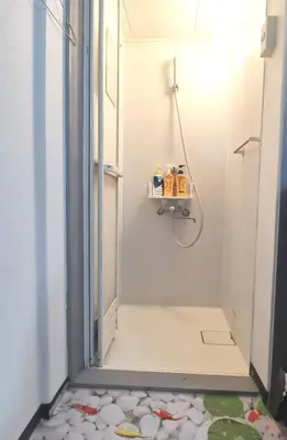 a small bathroom with a shower with a tile floor at White house in Tokyo