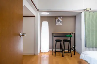 a room with two bar stools and a bed at \u6771\u4e0a\u91ce\u6238\u5efa in Tokyo