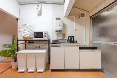 a kitchen with white cabinets and a microwave at \u6771\u4e0a\u91ce\u6238\u5efa in Tokyo