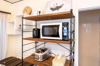 a microwave on a shelf in a room at \u897f\u65b0\u5bbf5\u4e01\u76ee\u6238\u5efa in Tokyo