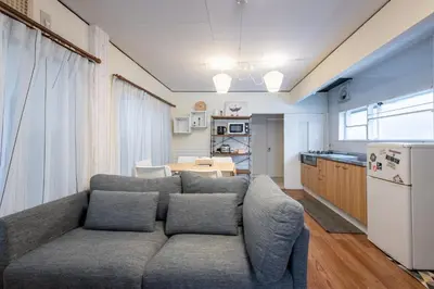 a living room with a couch and a kitchen at \u897f\u65b0\u5bbf5\u4e01\u76ee\u6238\u5efa in Tokyo