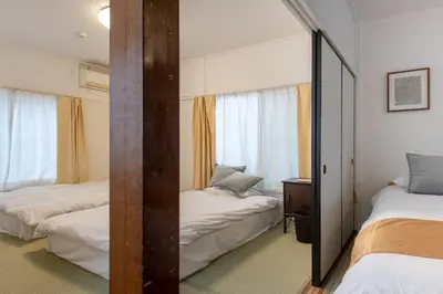 a bedroom with two beds and a mirror at \u897f\u65b0\u5bbf5\u4e01\u76ee\u6238\u5efa in Tokyo