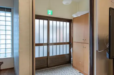 a room with a door with a sign on it at \u897f\u65b0\u5bbf5\u4e01\u76ee\u6238\u5efa in Tokyo