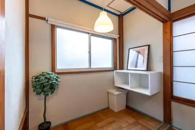 a hallway with a window and a potted plant at \u897f\u65b0\u5bbf5\u4e01\u76ee\u6238\u5efa in Tokyo