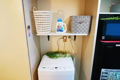 a laundry room with a washing machine and a shelf at SC 101 Cozy Private Stay with Loft Near Station Free WiFi in Tokyo