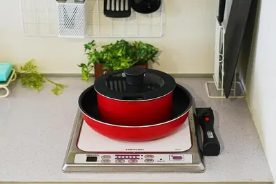 a red pot sitting on top of a stove at SC 101 Cozy Private Stay with Loft Near Station Free WiFi in Tokyo