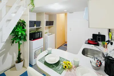 a kitchen with a sink and a table with dishes on it at SC 106 Cozy Private Stay with Loft Near Station Free WiFi in Tokyo