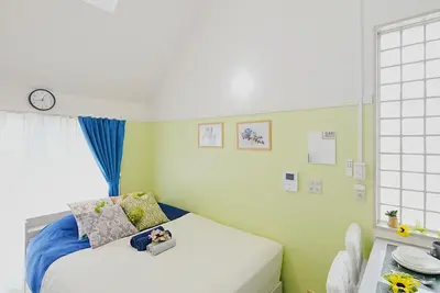 a bedroom with a bed and a clock on the wall at SC 201 Cozy Private Stay with Loft Near Station Free WiFi in Tokyo