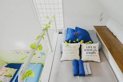 a small room with a bed with blue pillows at SC 201 Cozy Private Stay with Loft Near Station Free WiFi in Tokyo