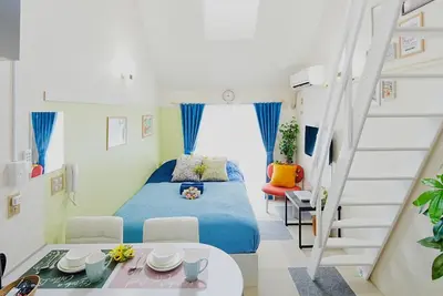 a small bedroom with a bed and a staircase at SC 203 Cozy Private Stay with Loft Near Station Free WiFi in Tokyo