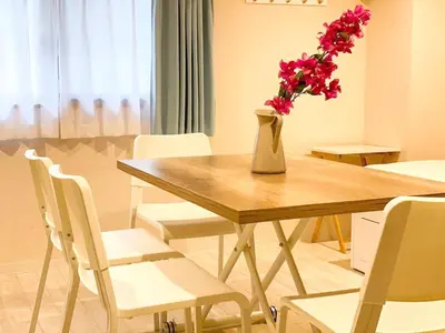 a dining room table with a vase with flowers in it at Dolce Shibuya in Tokyo
