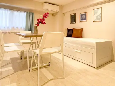 a bedroom with a bed and a table and chairs at Dolce Shibuya in Tokyo