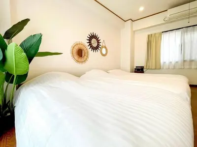 a bedroom with a white bed and a plant at SHOGUN Shibuya in Tokyo