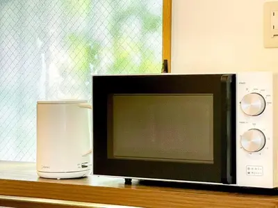 a microwave sitting on a counter next to a coffeeinder at SHOGUN Shibuya in Tokyo
