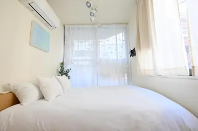 a bedroom with a white bed and a window at Shinjuku-2minutes Shin-Okubo\u99c5 Very good location in Tokyo
