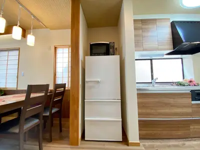 a kitchen with a white refrigerator and a table at N9-luxury guest room in Shinjuku in Tokyo
