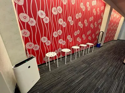 a row of stools in a room with a red wall at Hotel PRELE in Tokyo