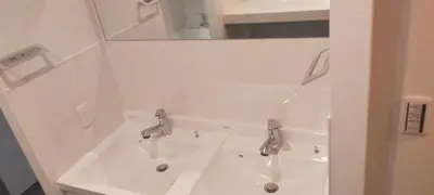 a white sink with two faucets and a mirror at Hotel PRELE in Tokyo