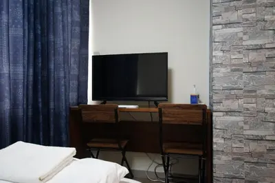 a room with a desk with a television and two chairs at TOKYOGUEST\u65e5\u672c\u6a4b in Tokyo