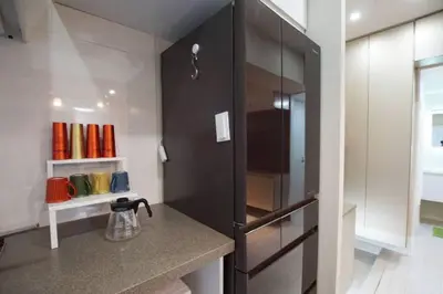 a kitchen with a black cabinet with a kettle on a counter at TOKYOGUEST\u65e5\u672c\u6a4b in Tokyo
