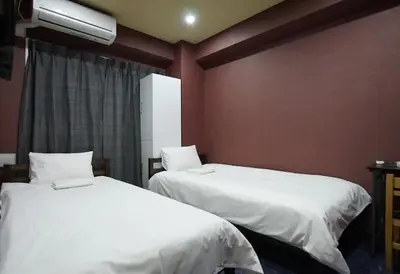 two beds in a room with red walls at TOKYOGUEST\u65e5\u672c\u6a4b in Tokyo