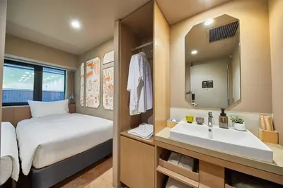 a small bathroom with a bed and a sink at lyf Ginza Tokyo in Tokyo
